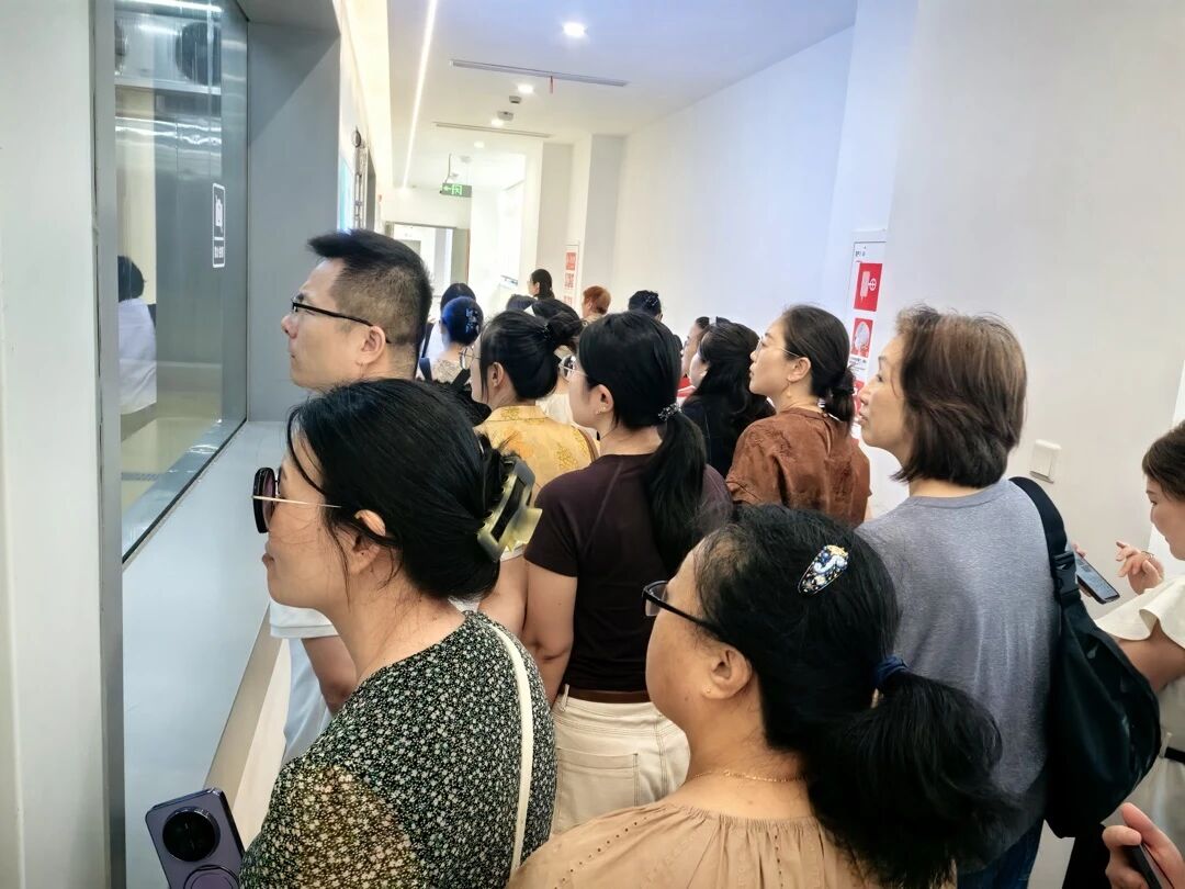 会员透过玻璃观看生产车间